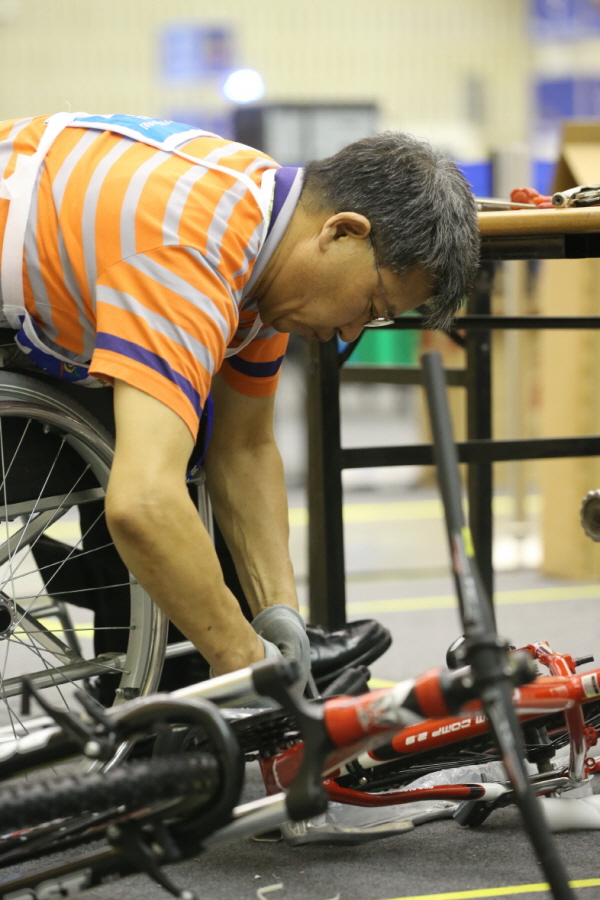 ▲ 제29회 전국장애인기능경기대회에 출전한 선수가 기계(자전거)조립 종목에 참가한 선수가 휠체어를 타고 경기에 임하고 있다.