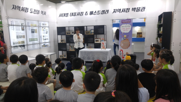 지난해 열린 서울국제도서전에서 '북샵 부스'내에 설치된 서점 박물관. 어린이들이 국내 지역서점의 역사와 흐름에 대한 설명을 듣고 있다. (사진 한국서점조합연합회)