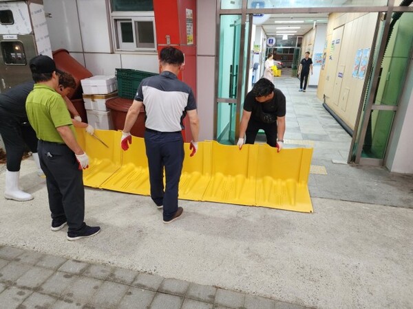 9일 오천시장 의용소방대원들이 제6호 태풍 ‘카눈’에 대비해 차수벽을 설치하고 있다.