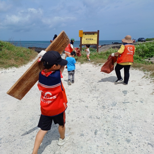 제주도에서 진행된 제1회 플로깅 행사에서 어린이가 바다에 버려진 쓰레기를 줍고있는 모습(출처=한국중앙자원봉사센터)